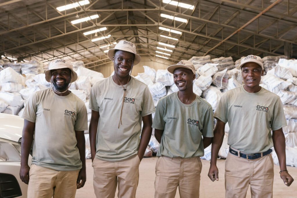 Team smiling in factory with wood